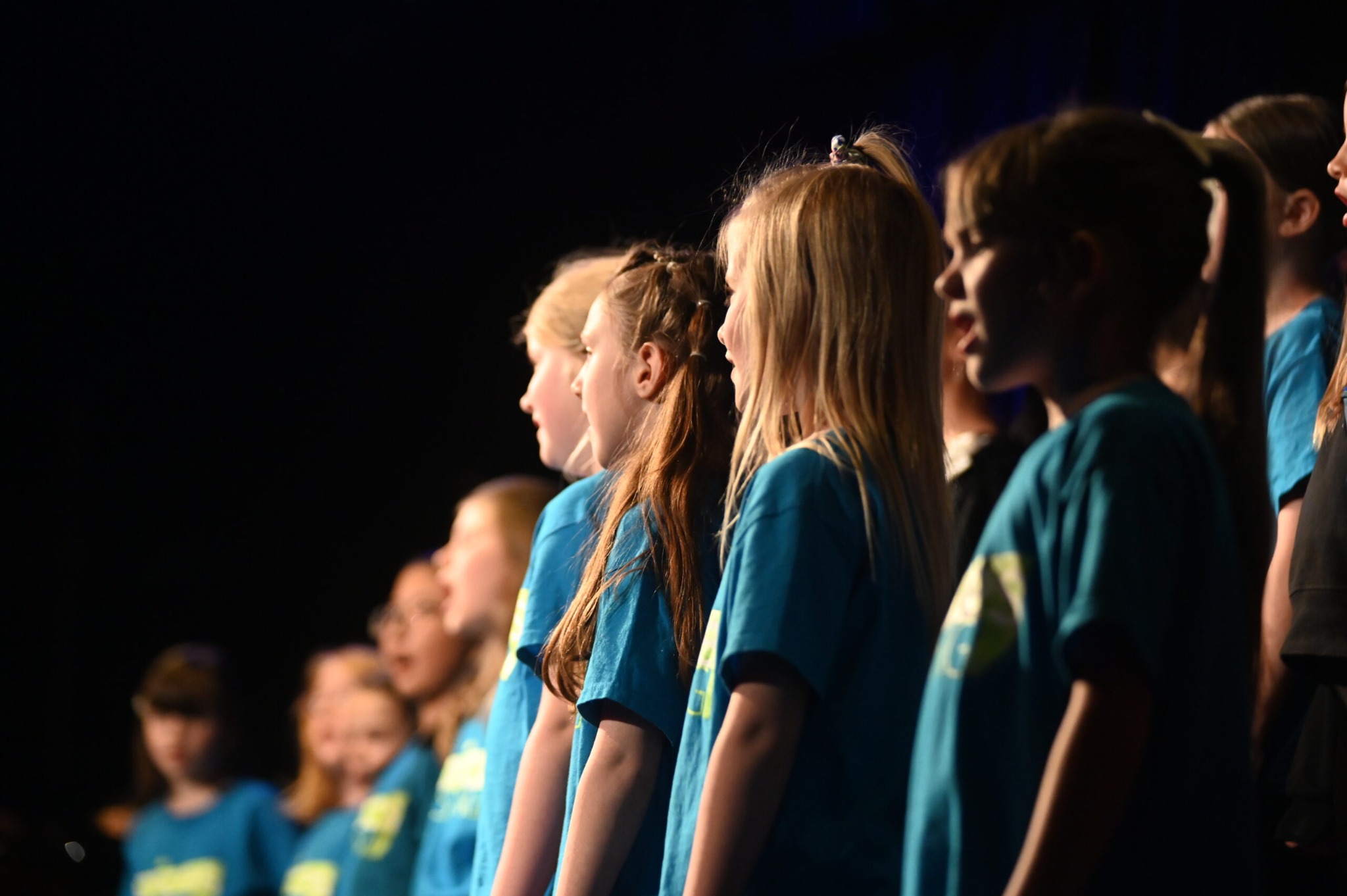 Voices Rising youth singers performing together on stage